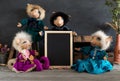 Collection handmade dolls with empty blackboard on the wooden ta