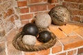 Collection of historical cannonballs and rope displayed in a brick corner of an old structure in a museum Royalty Free Stock Photo