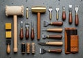 A collection of leather crafting tools neatly arranged on a textured gray surface. The set includes Royalty Free Stock Photo