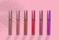 collection of liquid glossy lipstick tube on background, red, raspberry, pink, coral, peach color close-up, concept of decorative