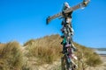 Collection lost footwear attached to cross on beach, Home of Lost Soles