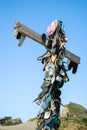 Collection lost footwear attached to cross on beach, Home of Lost Soles