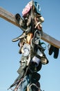 Collection lost footwear attached to cross on beach, Home of Lost Soles