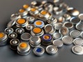 Collection of metallic objects including button cells, coins, key. Arranged in haphazard manner on gray background. Shiny Royalty Free Stock Photo
