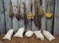 Collection, a mixture of various dried herbs in bundles and bags on a wooden background.