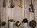 Collection, a mixture of various dried herbs in bundles, linen bags and cups on a wooden background.