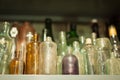 Collection of old dusty colored bottles of different shapes, sizes