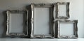 A collection of ornate silver frames against a muted grey wall , metallic, elegant Royalty Free Stock Photo