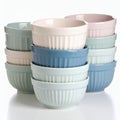 Stacked pastel ceramic ramekins present a soft and elegant kitchenware display on white background Royalty Free Stock Photo