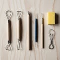 A collection of pottery tools laid out on a light wooden surface Royalty Free Stock Photo