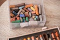 Collection of rainbow colored pastel crayons with crushed chalk on old wooden desk. Royalty Free Stock Photo