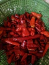 A collection of red chili pieces in a plastic baskets container