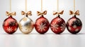 A collection of red, gold and clear Christmas baubles hanging from red ribbon