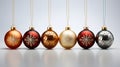 A collection of red, gold and clear Christmas baubles hanging from red ribbon