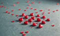 collection red heart-shaped objects, varying in size, is scattered across gray surface, creating visually Royalty Free Stock Photo