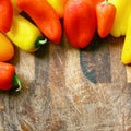 A collection of Red and Yellow Sweet Peppers BorderingWood Cutting Board Royalty Free Stock Photo