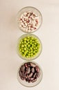 A collection set of various dried legumes in glass glasses arranged vertically green peas, red beans, white beans close-up on a Royalty Free Stock Photo