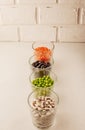 Collection set of various dried legumes in glass glasses arranged vertically green peas, red lentils, red beans, white beans close Royalty Free Stock Photo