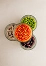 Collection set of various dried legumes in glass glasses stand in a pyramid: green peas, red beans, white beans close-up on a Royalty Free Stock Photo