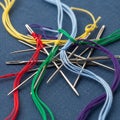 A collection of sewing needles is arranged on a blue fabric background Royalty Free Stock Photo