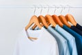 Collection shade of blue tone color t-shirts hanging on wooden clothes hanger in closet