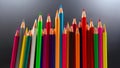 A collection of sharpened colored pencils in bright shades, organized in a visually appealing row against a minimalist gray Royalty Free Stock Photo
