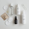 A collection of skincare products arranged on a white surface. It includes transparent