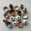 A collection of small ceramic bowls and vases arranged on a plain Royalty Free Stock Photo