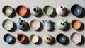 Collection of small ceramic pots and bowls arranged on a light textured Royalty Free Stock Photo