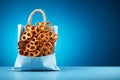 A collection of small pretzels arranged in front of a bag on a blue background, Generative Ai Royalty Free Stock Photo