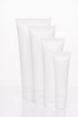 Collection of spray foam soap collagen creme concept. Vertical full length photo of four objects tubes for cosmetics with empty