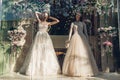 Collection of stylish wedding dresses on showcase of shop. Two mannequins wearing beautiful gowns on display