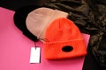 Collection of three hats in different colors with tags on bright background