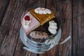 Collection of various cakes on wood background. Assortment of pieces slices with cream. Plate with different types of sweets.