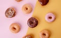 a collection of various donuts on pink and yellow background Royalty Free Stock Photo