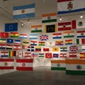 A collection of various flags is displayed indoors, hanging from ceiling rails and walls. Royalty Free Stock Photo