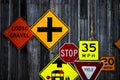 Collection of various road signs on rustic wooden wall