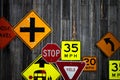 Collection of various road signs on rustic wooden wall