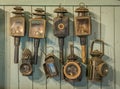 A collection of vintage hand lamps, hanging on a wooden wall