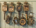 A collection of vintage hand lamps, hanging on a wooden wall