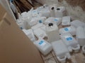 A collection of white jerry cans scattered on the floor.