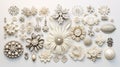 A collection of white and off-white brooches and pins arranged in a flat lay style on a white background, creating a