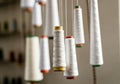 Spools of white thread hanging in a sewing workshop, showcasing craftsmanship Royalty Free Stock Photo