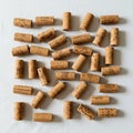 A collection of wine corks scattered on a white surface. The corks are made from Royalty Free Stock Photo