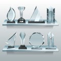 Collections of transparent trophies, awards and winner cups on shelf of glass