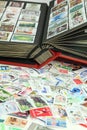 Collector`s postage stamps in front of an album Royalty Free Stock Photo