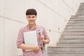 College asian male student holding laptop in campus