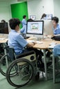 In a college in Bangkok, a disabled student in computer class.