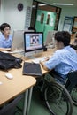 In a college in Bangkok, a disabled student in computer class.