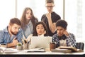 College classmates doing group project at library using laptop